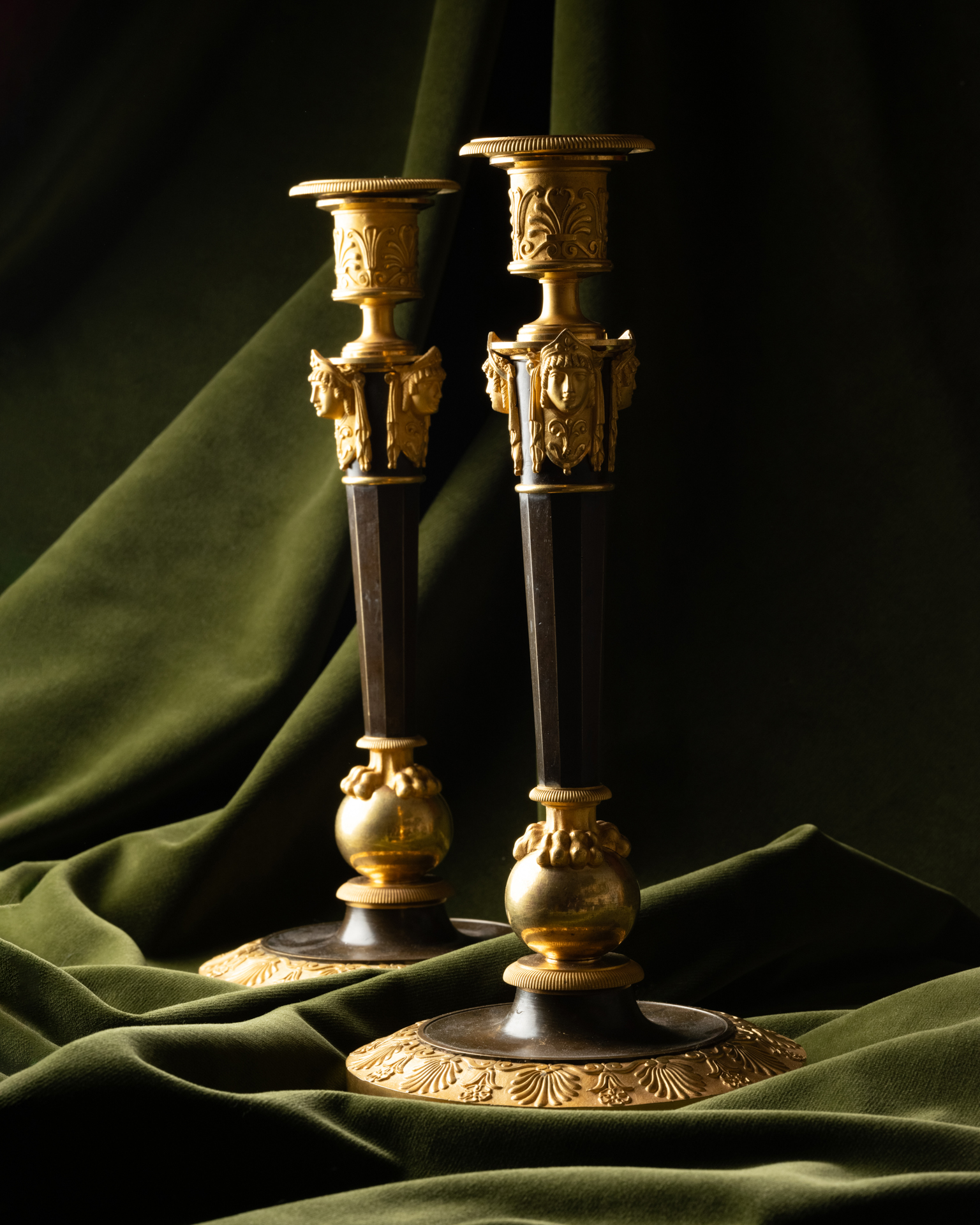 A Set of Four Empire Parcel-Gilt “Claw-Foot” Candlesticks with Antique Masks, attributed to Claude Galle